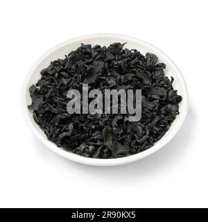 White bowl with dried wakame seaweed close up isolated on white background Stock Photo