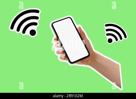 Cut out style composite image wi-fi icons and photo of smart phone with blank white screen in a hand on green background. Stock Photo