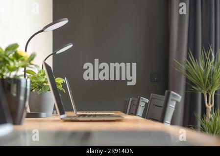 Modern coworking office interior with laptops, table lamps. Selective focus. Stock Photo