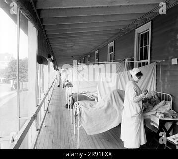 Washington, D.C.:  c. 1918 A nurse checking on a patient at the Walter Reed Hospital Flu Ward during the influenza pandemic. Stock Photo