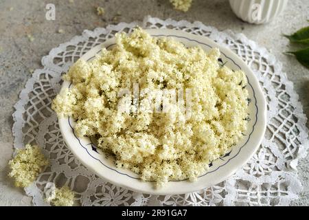 Black elder flowers collected in june in a plate on a table Stock Photo