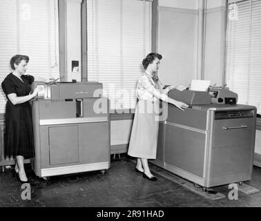 Cleveland, Ohio:  c. 1954  Women using two different IBM punch card machines. On the left is a Summary Punch Machine, and on the right is the type 407 Alphabetic Accounting Machine which tabulates and prints. Stock Photo