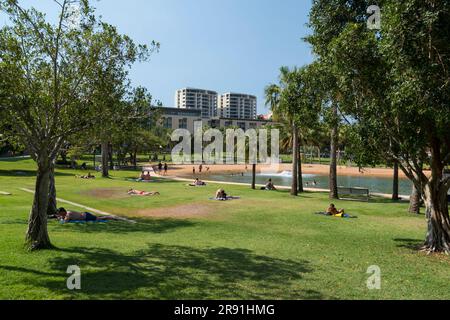 People relax in the sun on the grass in Darwin Waterfront Precinct in the Northern Territory in Australia Stock Photo