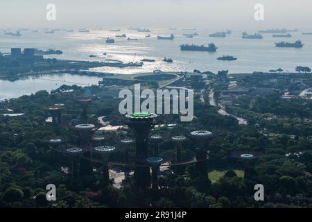 An elevated view of Singapore with container ships waiting off shore. Stock Photo
