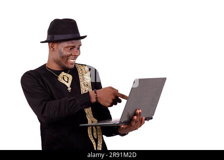 well-dressed young man pointing finger at laptop screen while smiling. Stock Photo