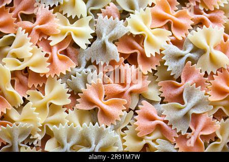 Close-up on a stack of colorful uncooked farfalle from Italy. Stock Photo