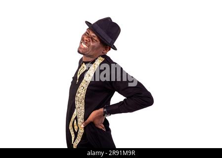 young man holds his hands behind his back, suffering from back pain. Stock Photo