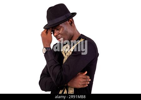 portrait of well-dressed young man thinking with crossed arm and raised hand near face. Stock Photo