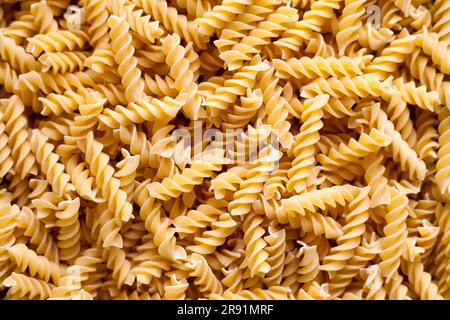Full-frame close-up on a stack of uncooked fusilli. Stock Photo