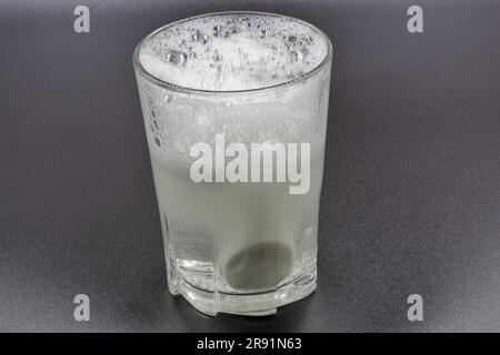 Dissolving instant effervescent tablets in a glass of water closeup on black Stock Photo