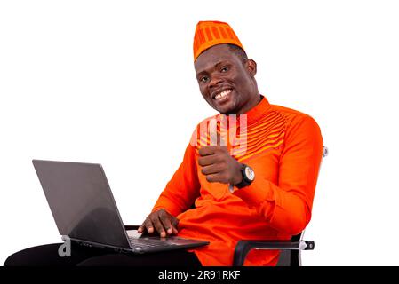 handsome man in hat at home on white background working using laptop computer making okay gesture and looking at camera smiling. Stock Photo