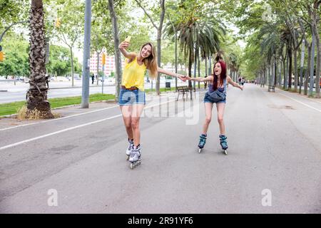 Friends inline skating and taking selfie using smart phone on street Stock Photo