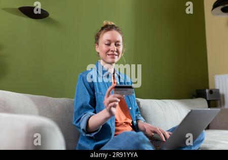 Young woman doing online shopping sitting at home Stock Photo