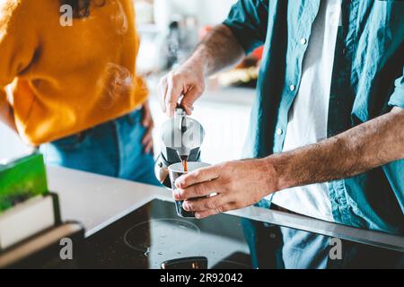 Man pouring coffee in cup at home Stock Photo