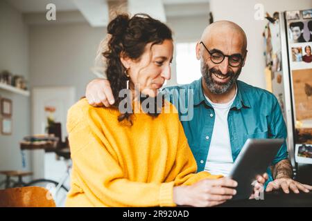 Happy couple using tablet PC at home Stock Photo