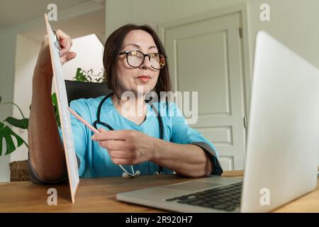 Doctor advising patient through video call on laptop at medical practice Stock Photo