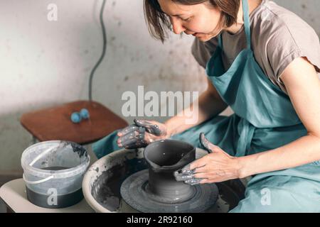 Potter wearing apron making ceramic pot at workshop Stock Photo