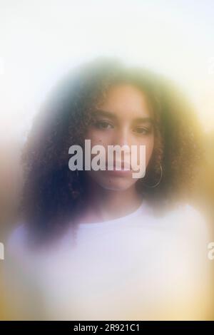 Serious young woman with curly hair Stock Photo