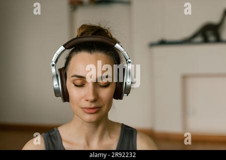 Woman listening music with headphones and meditating at home Stock Photo