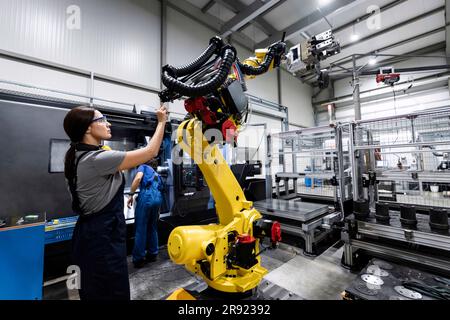 Maintenance engineer working in factory using robotic arm Stock Photo