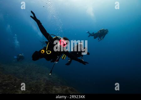 Young men and woman doing scuba diving undersea Stock Photo