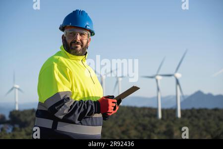 Contemplative engineer holding tablet PC at wind park Stock Photo