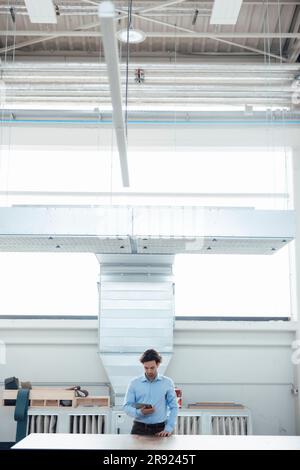 Businessman using tablet PC standing at industry Stock Photo