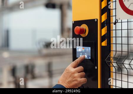 Hand of senior businessman operating security system in factory Stock Photo