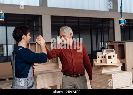Businessman with colleague giving high-five to each other Stock Photo