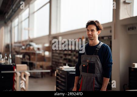 Smiling carpenter standing in workshop Stock Photo