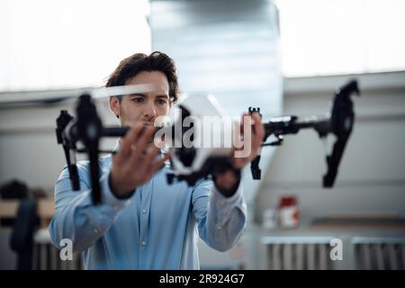 Young businessman examining drone in factory Stock Photo