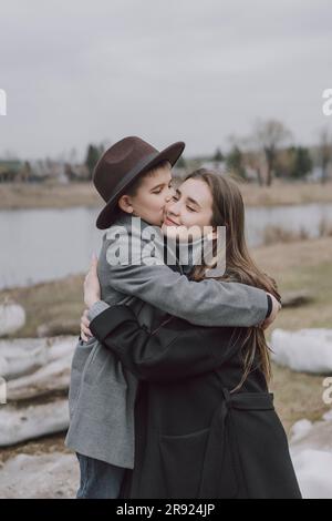 Son kissing and embracing mother on field Stock Photo