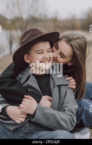 Mother embracing son sitting on field Stock Photo