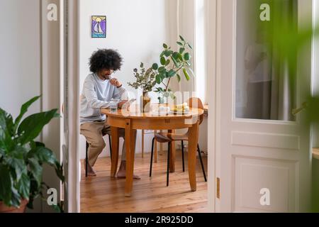 Young man using mobile phone at home Stock Photo