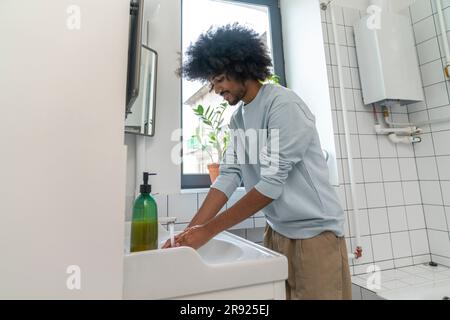 Man washing hands in bathroom at home Stock Photo