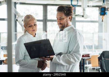 Scientists together discussing over laptop Stock Photo