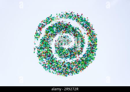 On a white background, a pattern of small colored beads in the form of a spiral. Stock Photo