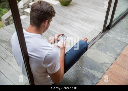 Young man using smart phone at home Stock Photo