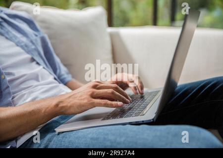 Hands of freelancer typing on laptop at home Stock Photo