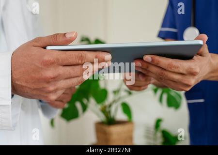 Doctors checking tablet PC at healthcare clinic Stock Photo