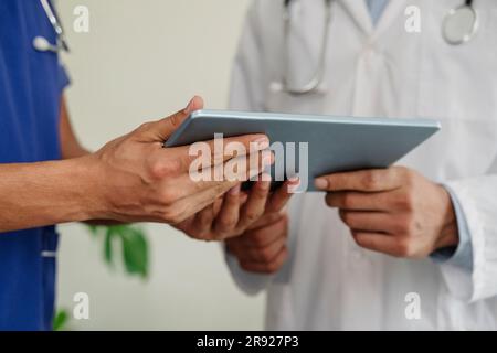 Doctors discussing over tablet PC at healthcare clinic Stock Photo