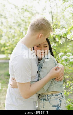 Happy young couple embracing at park Stock Photo