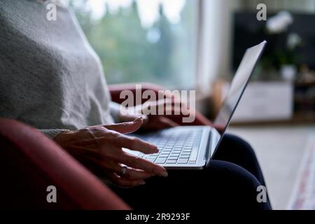 Senior woman using laptop at home Stock Photo