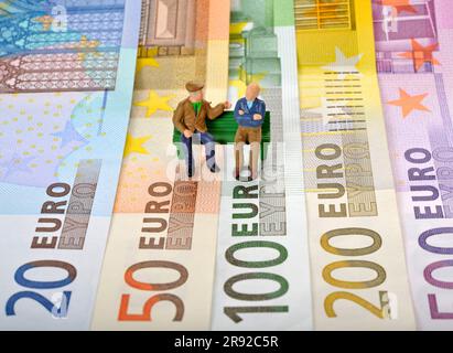 figures on euro bills, two pensioners sitting on a park bench Stock Photo