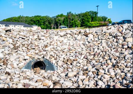 underground drainage storm drain with winged walls surrounded by rock for erosion control  Stock Photo