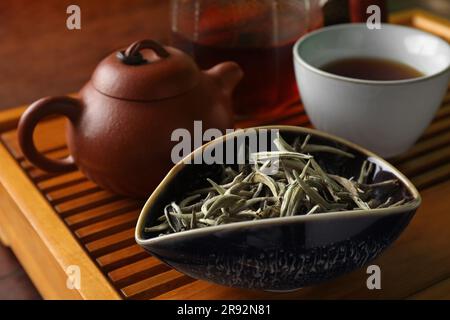 Aromatic Baihao Yinzhen tea and teapot on wooden tray, closeup. Traditional ceremony Stock Photo