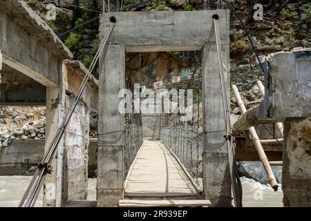 Pedestrian wooden and steel rope bridge over water a river Stock Photo