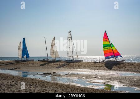 Colorful sails of sailboats on the beach along the Dutch North Sea coast. Stock Photo