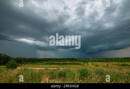 Menacing looking hailstorm with green colors over the flat landscape Stock Photo