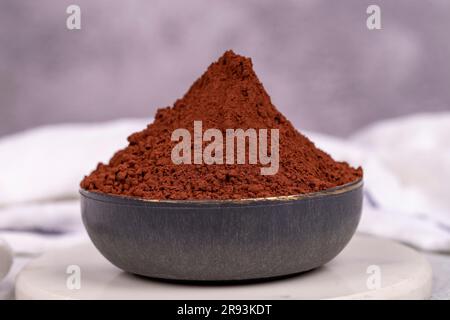 Cocoa powder on gray background. Cocoa powder in bowl Stock Photo